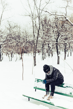 Lonely sad girl in winter parkの写真素材