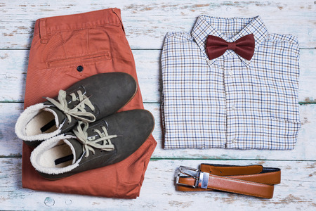 Clothes overhead. Pants, shoes, shirt, bowtie and belt on white vintage backgroundの写真素材