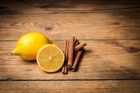 Lemon and cinnamon on old wooden backgroundの写真素材