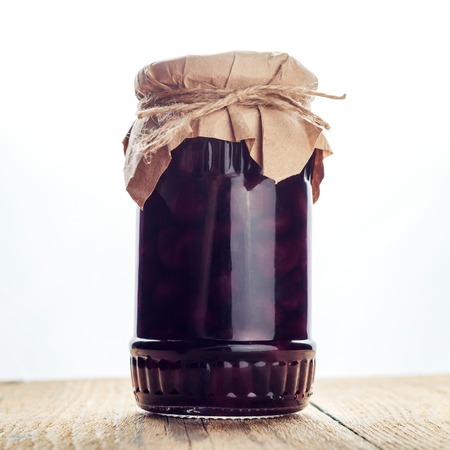 Natural fruit jam preserves jar cherry marmalade on wooden backgroundの写真素材