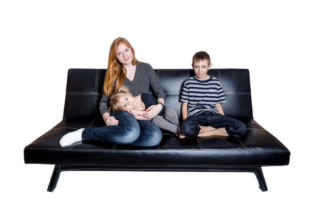 Mama with kids at the sofa isolated on white backgroundの写真素材