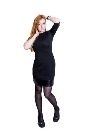 Red haired businness girl in black dress isolated on white backgroundの写真素材
