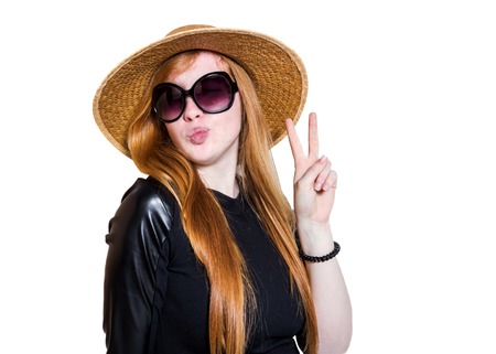 Portrait of attractive young woman in hat and sunglasses isolated on  white backgroundの写真素材