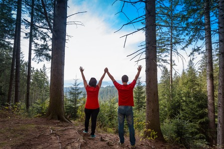 Loving couple standing on peak of mountain  hand by handの写真素材