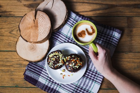 Cappuccino and chocolate cupcakes on wooden backgroundの写真素材