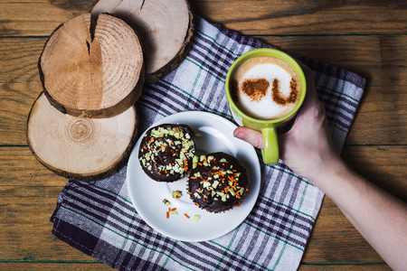 Cappuccino and chocolate cupcakes on wooden backgroundの写真素材