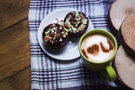 Cappuccino and chocolate cupcakes on wooden backgroundの写真素材