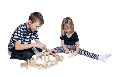 Girl and boy playing blocks Jenga isolated on white backgroundの写真素材