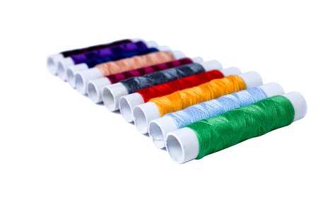 Pile of many-coloured bobbins of thread isolated on white backgroundの写真素材