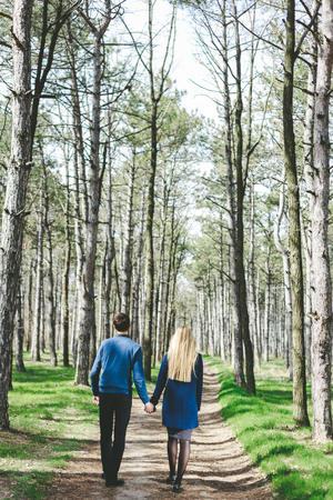 Stunning sensual outdoor portrait of young stylish fashion couple in forest at springの写真素材