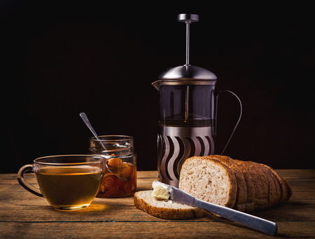 Breakfast with toast, jam and black tea, closeup on wooden backgroundの写真素材