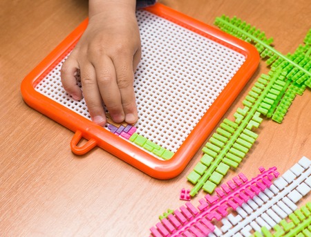 Close-up of the child's hands assembling puzzleの写真素材