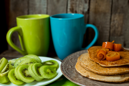 Hot drinks with puncakes on a wooden table for breakfastの写真素材