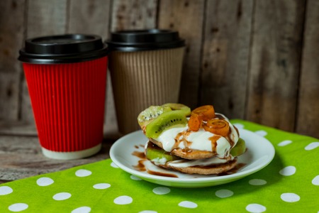 Hot drinks with puncakes on a wooden table for breakfastの写真素材