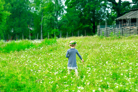 Little girl with dandelions on the flower fieldの写真素材
