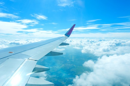 Airplane flying above clouds at sunriseの写真素材