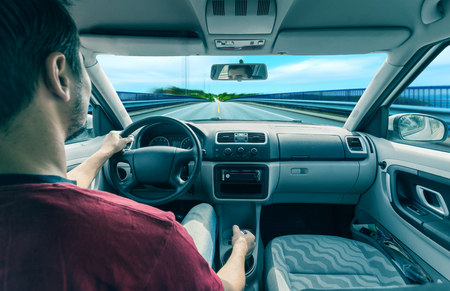 Hand on Wheel Car Driving. Driving Modern Car Steering Wheel and the Hand Closeup.の写真素材