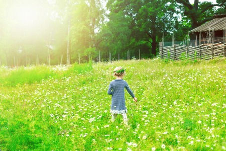 Little girl with dandelions on the flower fieldの写真素材