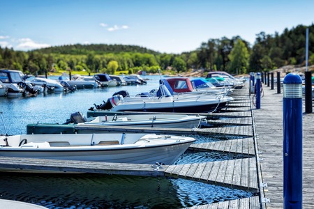 Picture of row of luxury sailboats reflected in water, yacht port on the bay, water transport, ocean transportation, beautiful vessel in the harbor, summer vacation, active lifestyle, holiday conceptの写真素材