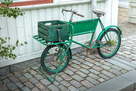 Old bicycle in front of a house in the cozy streetの写真素材