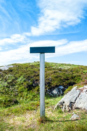 cardboard sign in a green grass, nature background, empty blue skyの写真素材