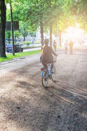 Young girl on a bicycle spring morning in the city with sunshineの写真素材