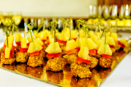 Catering service plate. Appetizing sandwiches on plastic sticks range. Sandwiches on a table the buffet. meat, fish, vegetable canapes on a festive wedding table outdoorの写真素材