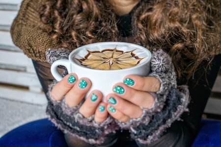 hands holding hot cup of coffee or tea in winter morningの写真素材