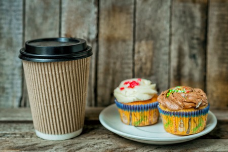 Cappuccino, coffee and cupcake in rustic style on wooden tableの写真素材
