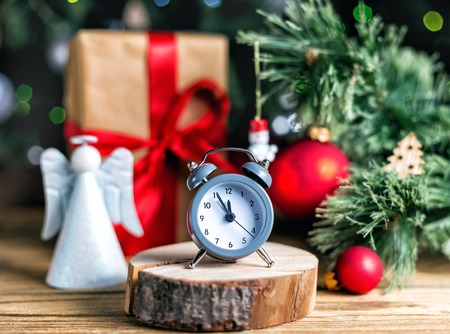 Christmas decoration red ball, baubles, angel and antique clock on wooden backgroundの写真素材