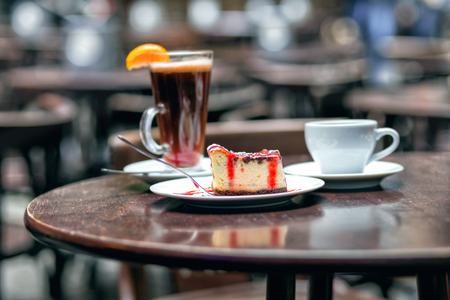 Slice of cheesecake with cherry and cup teaの写真素材