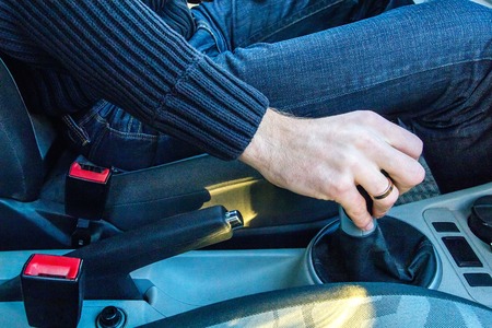 Man's hand on a mechanical gearbox in the carの写真素材