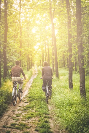 Happy couple riding bicycles outsideの写真素材