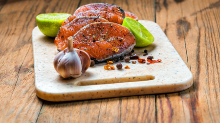Raw marinated trout fillet on wooden cutting board. Steak of salmon ready to fryingの写真素材