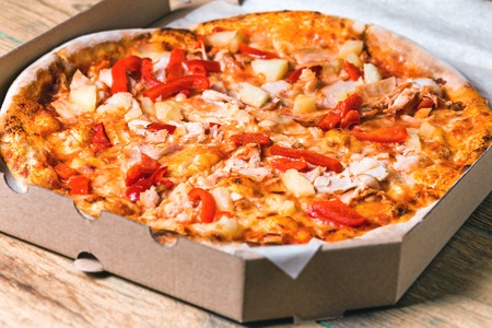 Pizza in box on wooden tableの写真素材