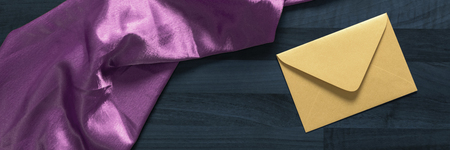 envelope and pink textile on the dark wooden gray tableの写真素材