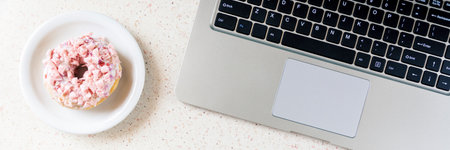 donut on plate laptop and pen on the table horizontal, panoramaの写真素材