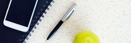 smartphone notebook pen and apple on the table panorama, panoramic, horizontalの写真素材