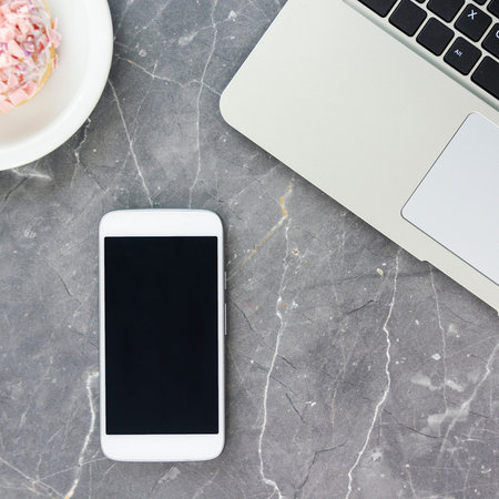 white smartphone over laptop on table square, cube, quad