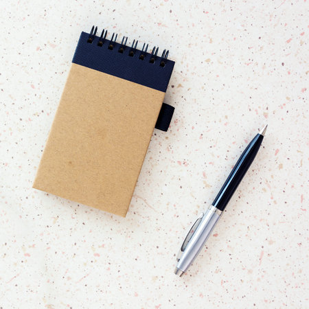 top of the desk with grapefruit on plate notebook and silver pen cube, square