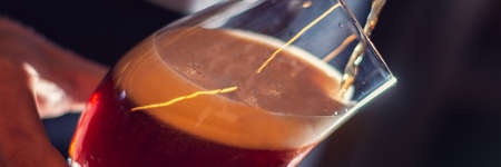 barman pour craft beer to the glass panoramaの写真素材