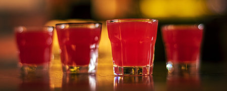 glass of alcohol shots on blurred background panoramaの写真素材