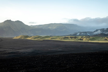 Icelandic landscape with mountains and black volcanic sand at sunrise.の写真素材