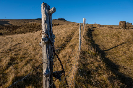 Wooden fence with barbed wire on the background of a mountain landscapeの写真素材