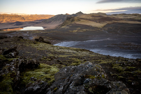 Icelandic landscape with lava field, lake and mountains at sunsetの写真素材