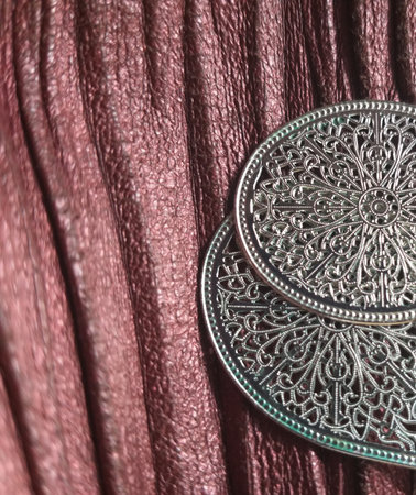 Old silver coin with a pattern on a background of a red curtainの写真素材