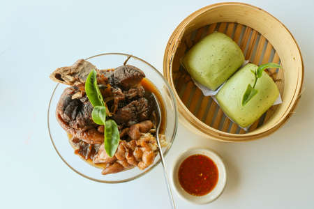 Steam pork leg with green tea buns and chili sauce in white backgroundの写真素材