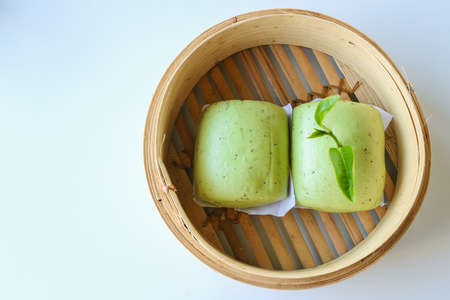Chinese green tea buns on bamboo basket in white backgroundの写真素材