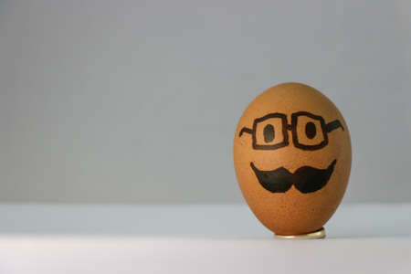 Isolated Easter egg, man face drawing in egg on white backgroundの写真素材