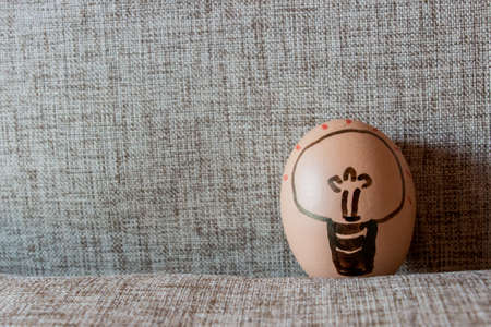 Idea Easter egg, Bulb drawing in egg with sackcloth backgroundの写真素材